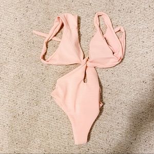Cut-out pink one piece bathing suit.